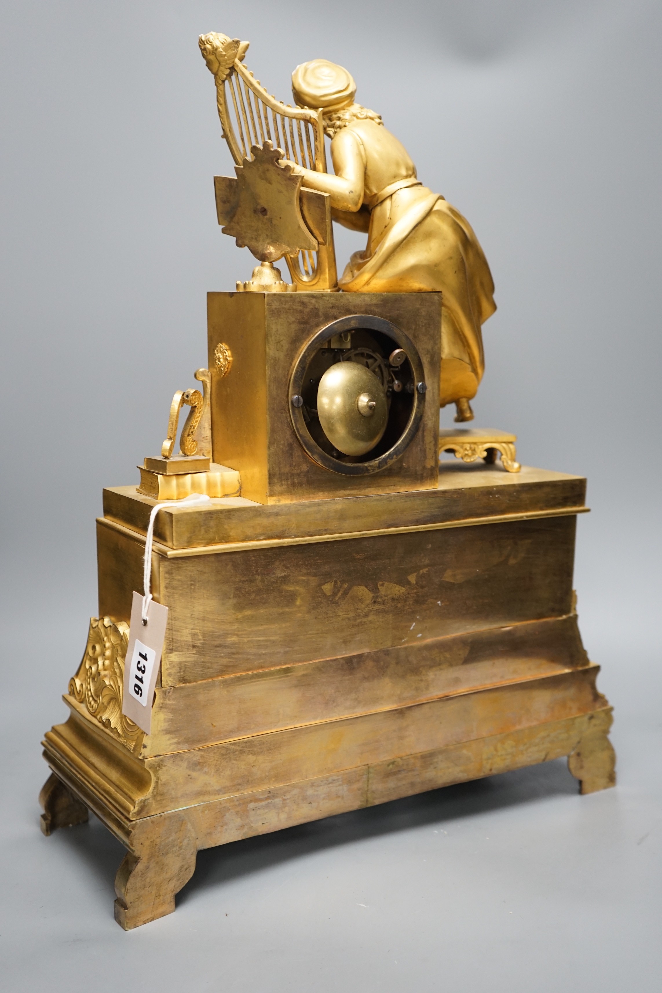 A 19th century French ormolu mounted clock with seated female Harpist decoration, with key, 49cm tall